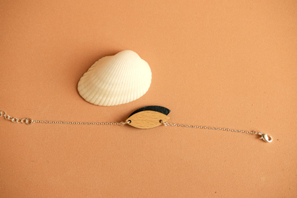 Le bracelet Mini pétale confère au poignet une esthétique à la fois minimaliste et sophistiquée. Il mixe un petit pétale de cuir bicolore à un autre en bois naturel.